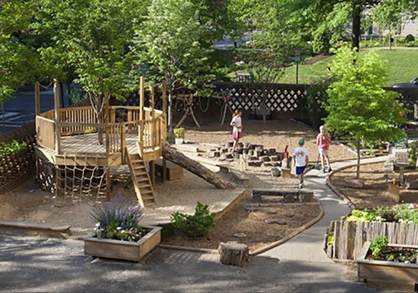 an aerial view of a children's play area with trees and people in the background