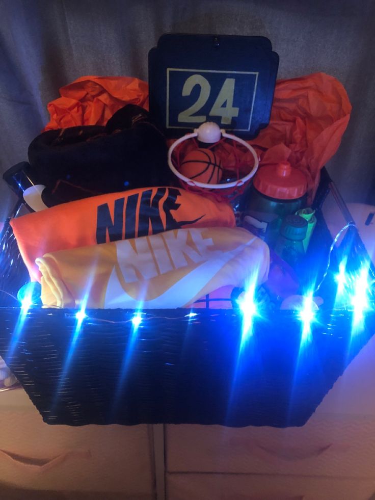 a basket filled with sports gear and items on top of a wooden table next to a basketball hoop