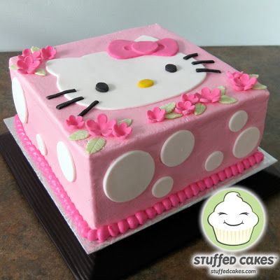 a hello kitty cake with pink icing and flowers