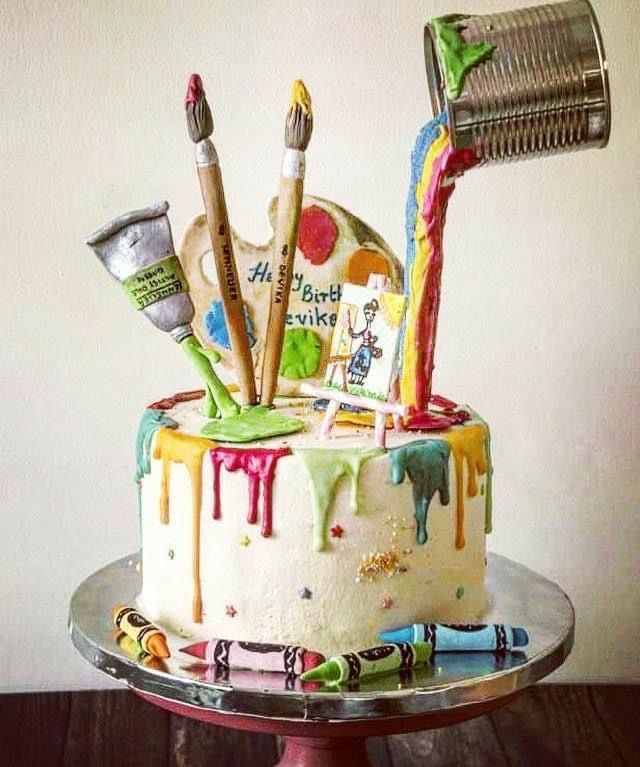 there is a cake that has been decorated with art supplies