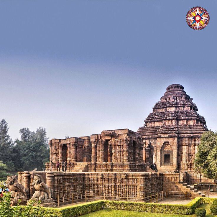 an ancient building in the middle of a lush green field with trees and bushes around it