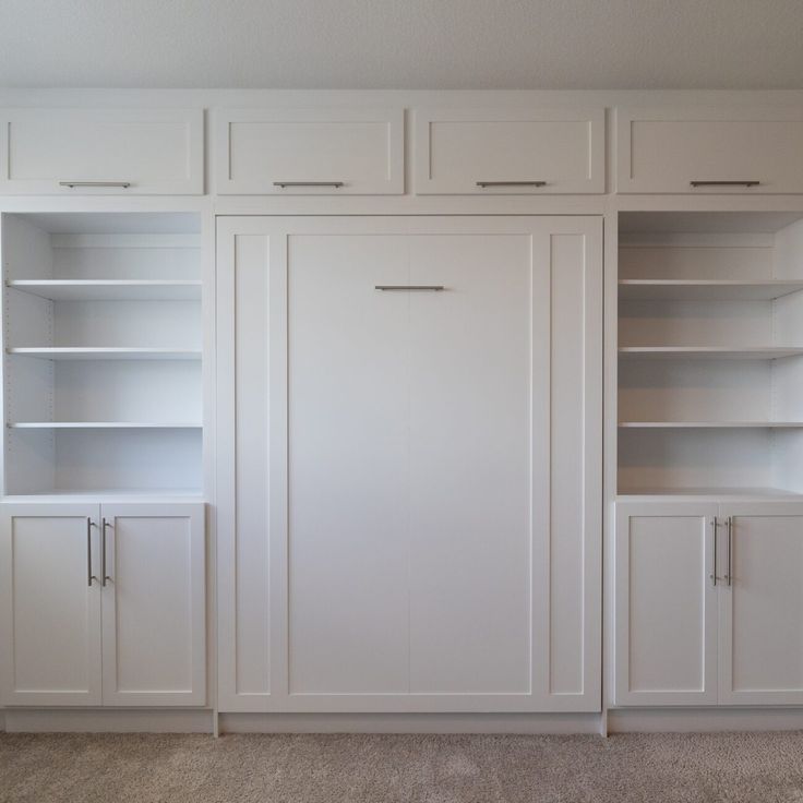 an empty room with white cabinets and carpet