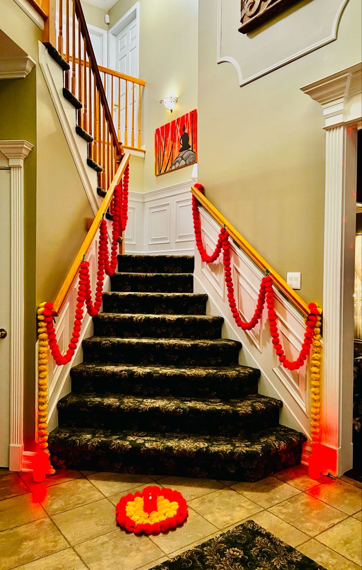 the stairs are decorated with red ribbon and garlands, along with decorations on either side