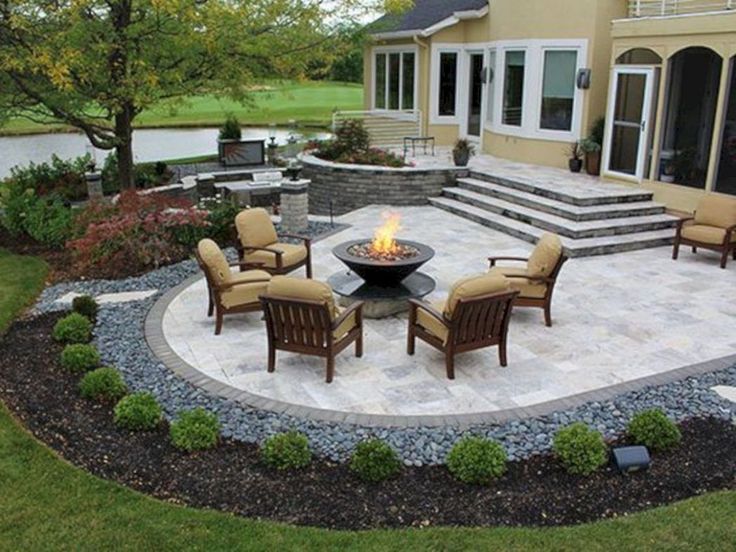 a patio with chairs and fire pit in the middle