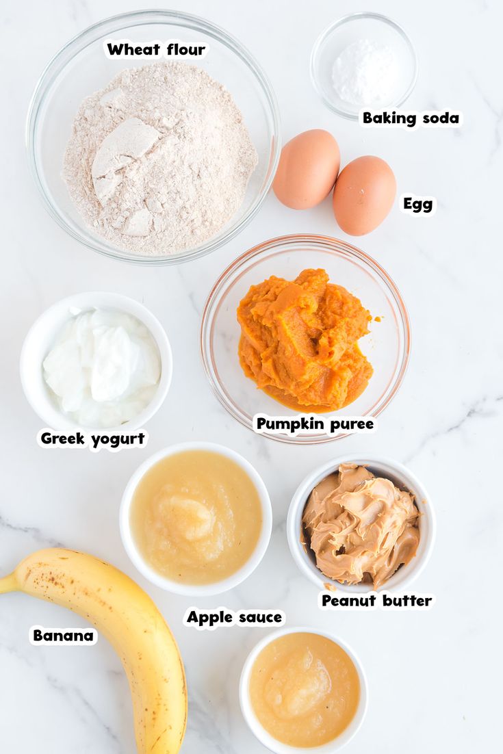 ingredients to make pumpkin muffins laid out on a white marble counter top with text