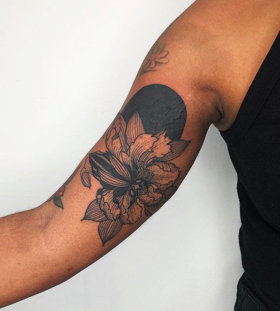 a man with a flower tattoo on his arm