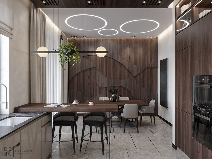 a dining room and kitchen area with wood paneling on the walls, ceiling lights and counter tops