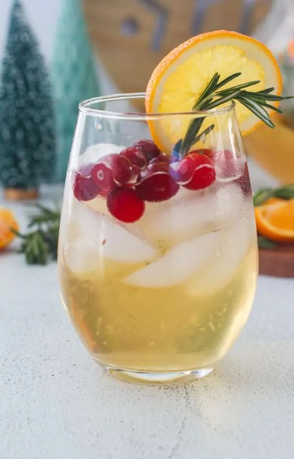 a glass filled with ice and fruit on top of a table