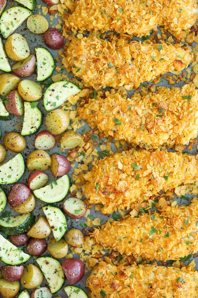 fried chicken with potatoes and cucumbers on a baking sheet, ready to be served