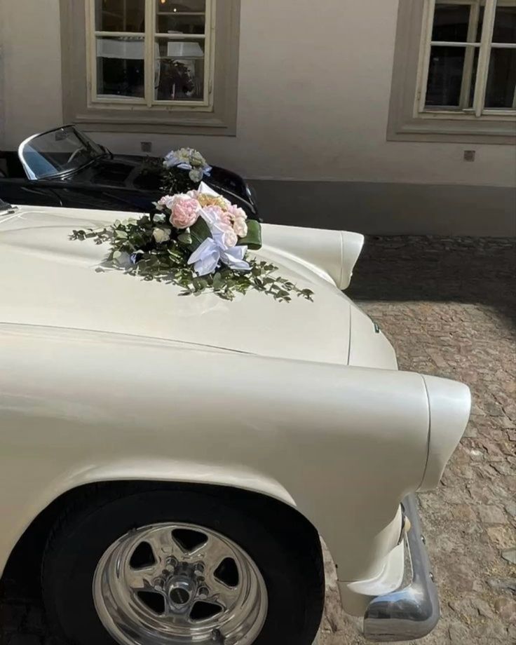 a white car with flowers on the hood