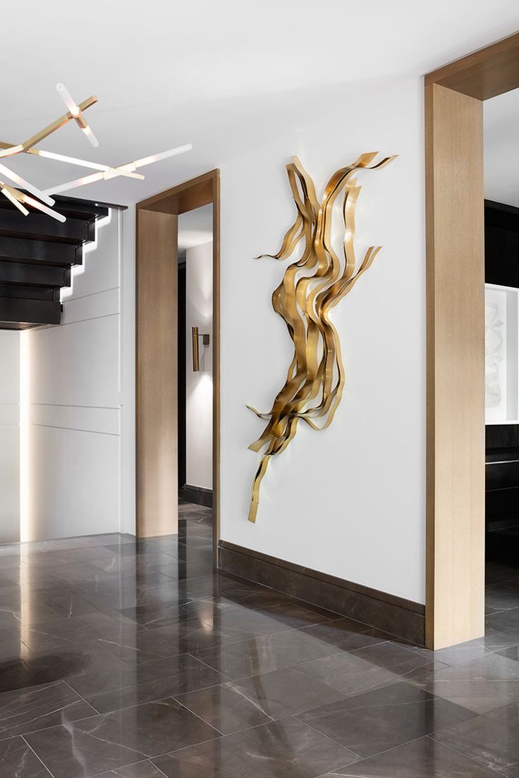 a large metal sculpture in the middle of a room next to a spiral stair case