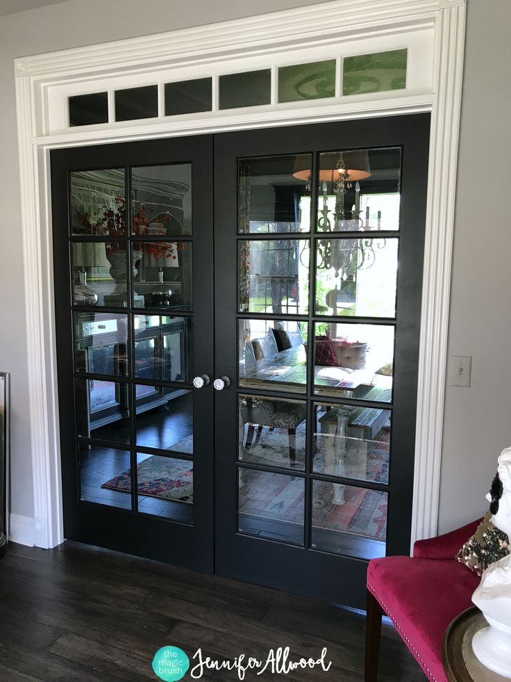 a black double door with glass panels on the inside and outside doors that lead into a living room