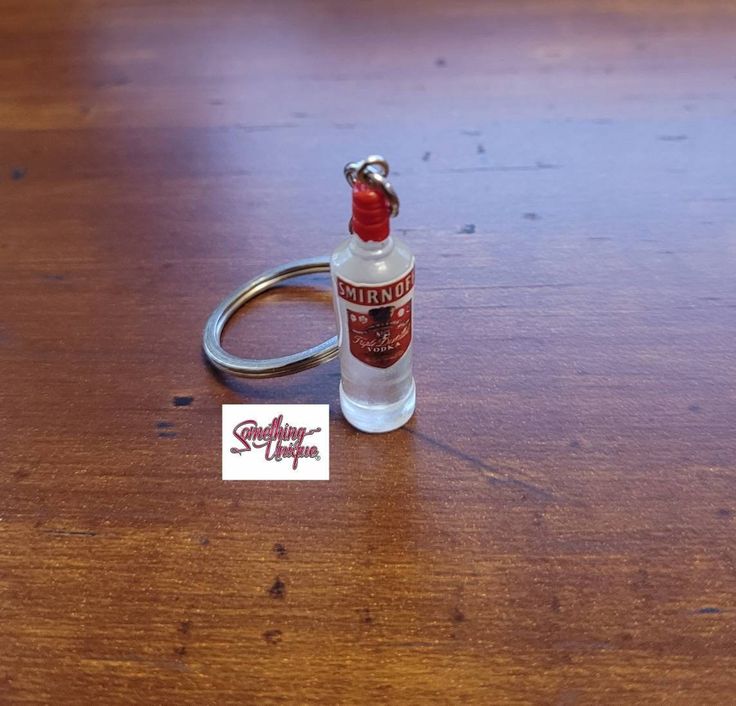 a bottle of alcohol sitting on top of a wooden table next to a pair of scissors