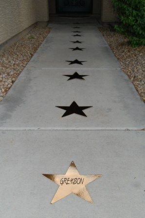 the sidewalk is lined with three star decorations