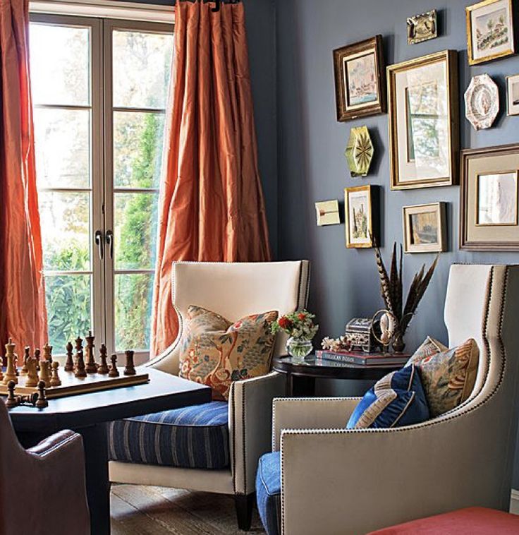 a living room filled with furniture and framed pictures on the wall next to a window