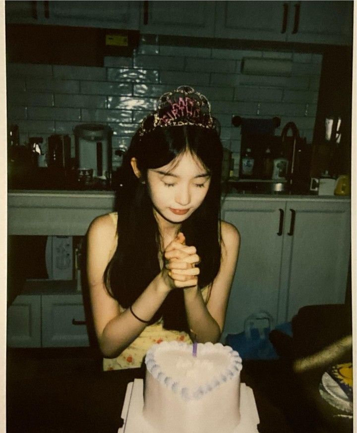 a woman sitting at a table in front of a cake