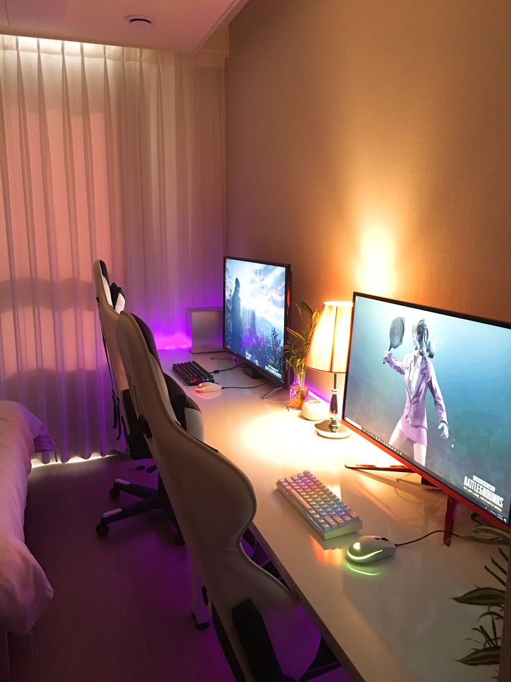 a bedroom with two computer monitors and a keyboard on the desk in front of it