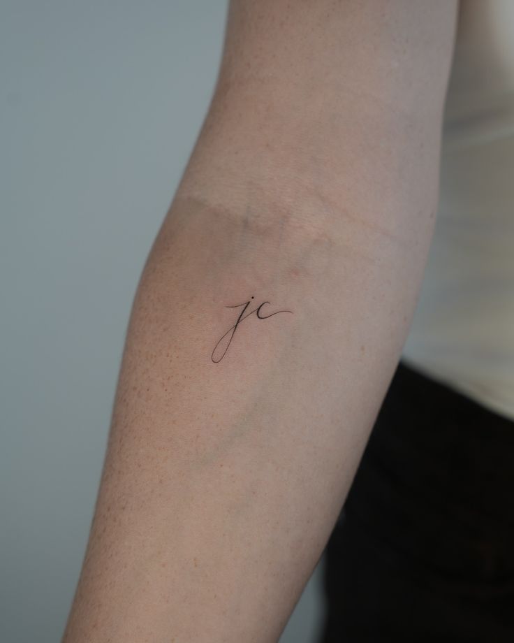 a woman's arm with a small tattoo on the left side of her arm