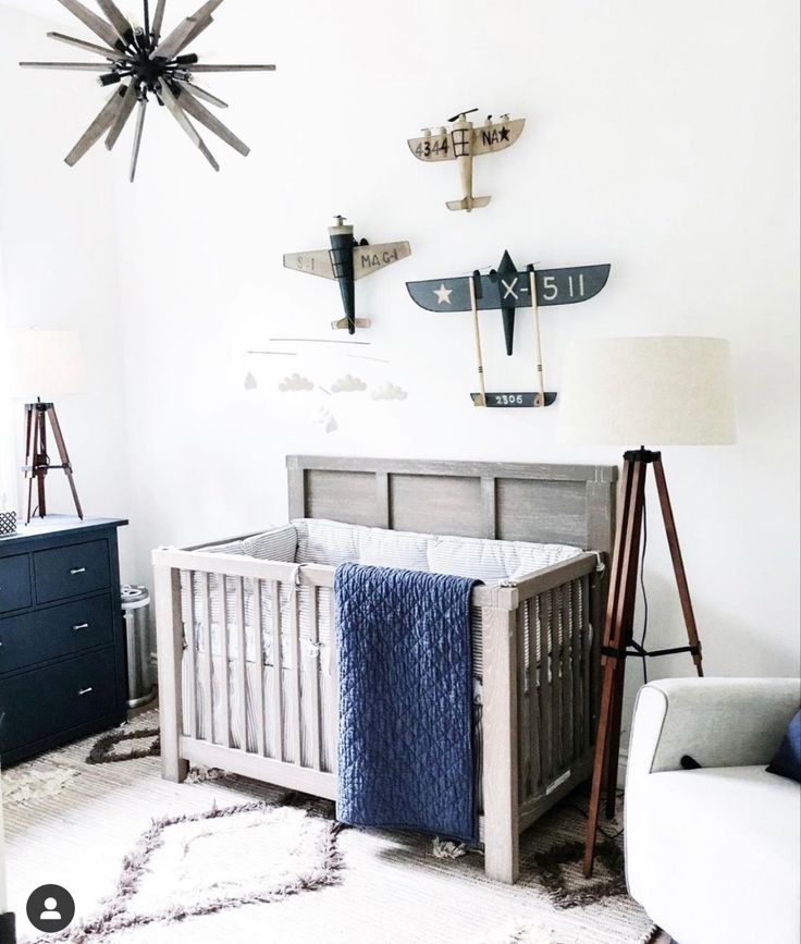 a baby's room with a crib, rocking chair and airplane decorations on the wall