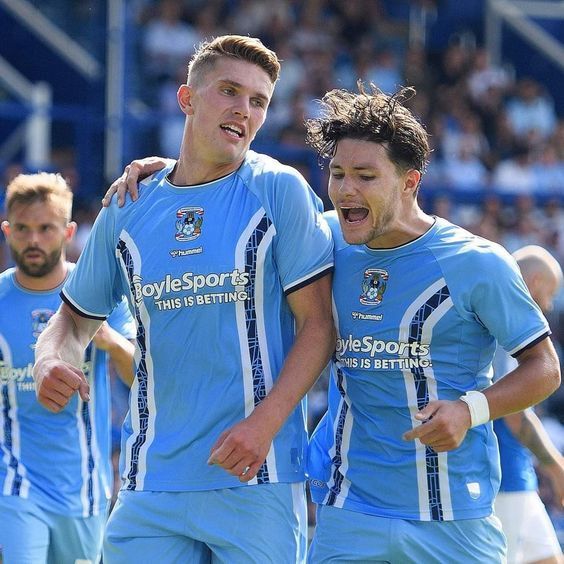 two soccer players in blue uniforms are celebrating