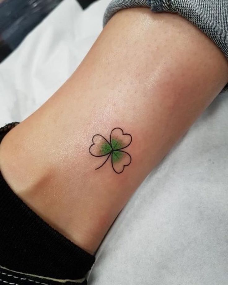 a small four leaf clover tattoo on the ankle