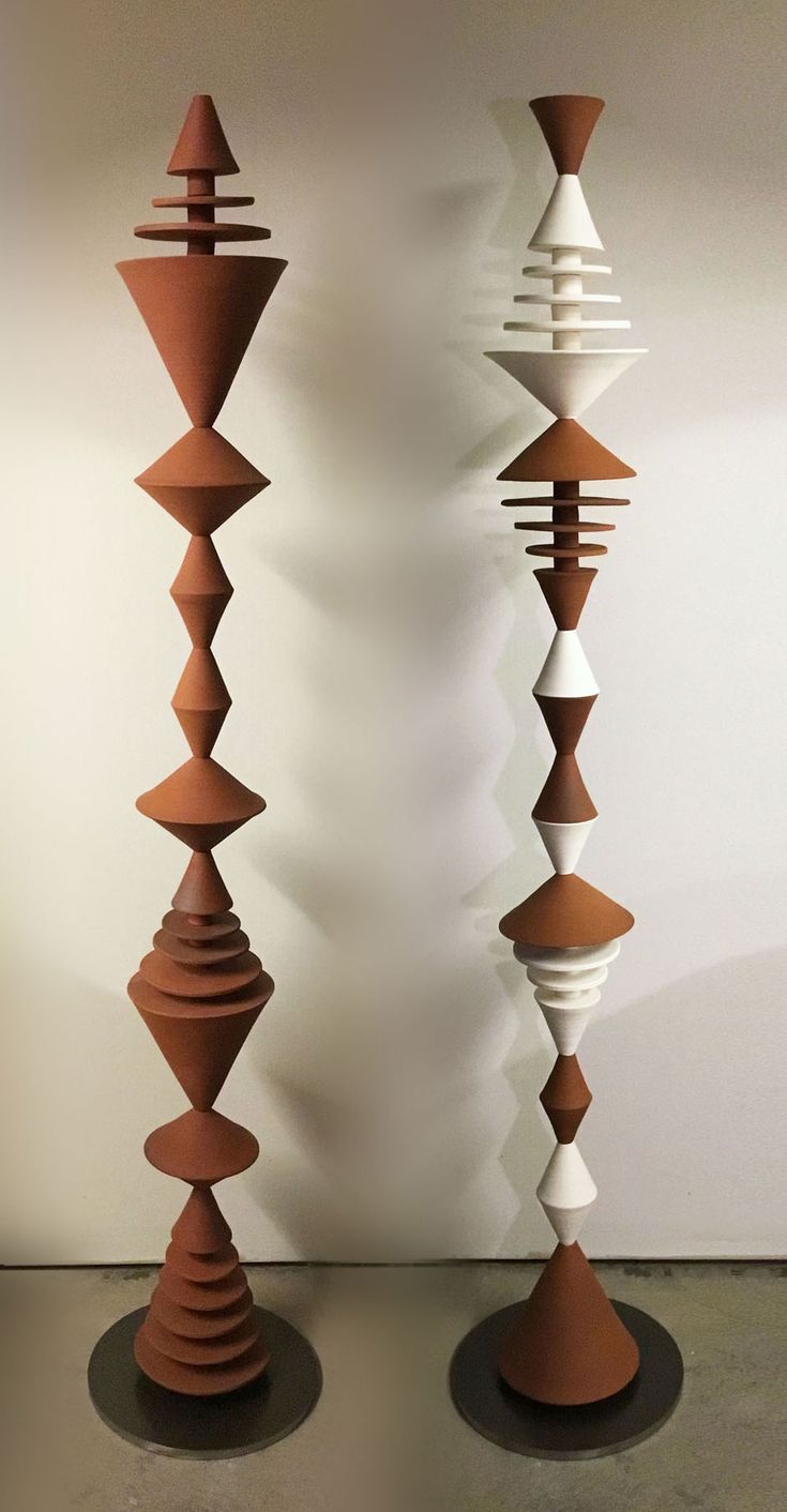 two tall brown and white vases sitting next to each other