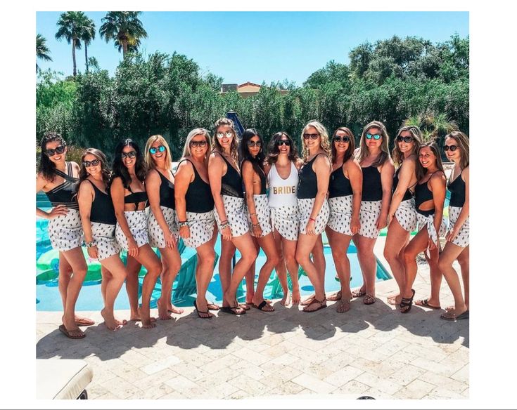 a group of women standing next to each other near a pool