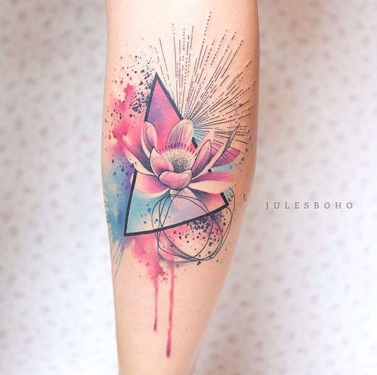 a woman's leg with a watercolor lotus tattoo design on the left calf