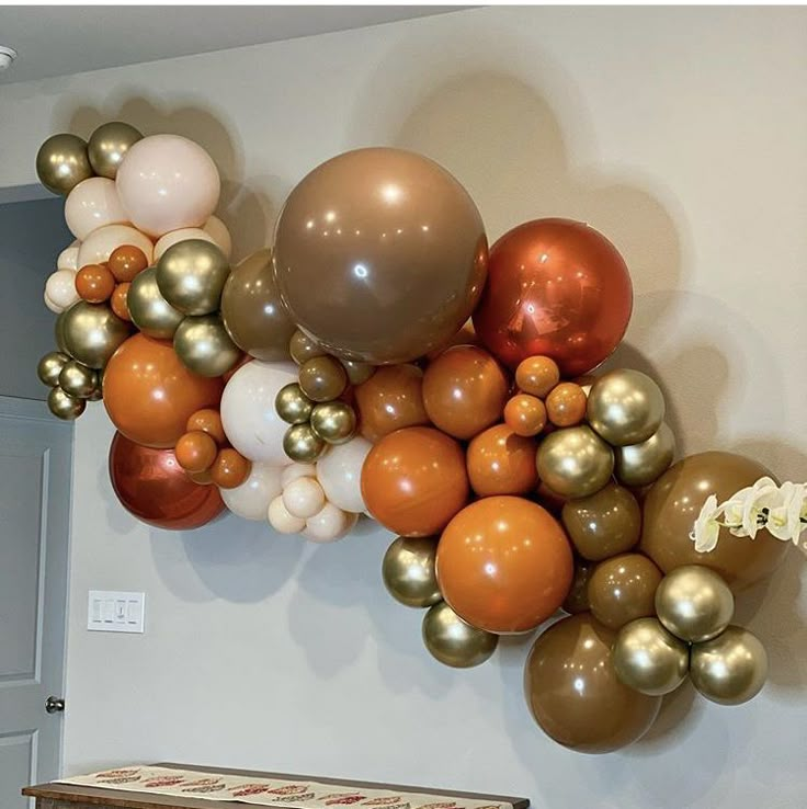 a bunch of balloons that are on the wall above a dresser and table in a room