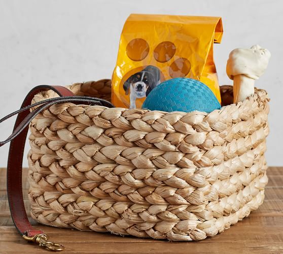 a dog is sitting in a basket with toys