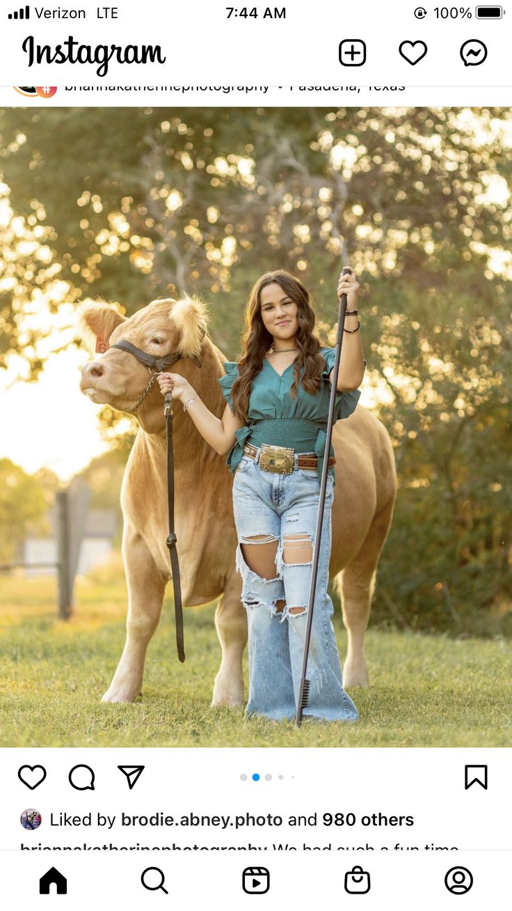 a woman is standing next to a brown horse and holding a stick in her hand