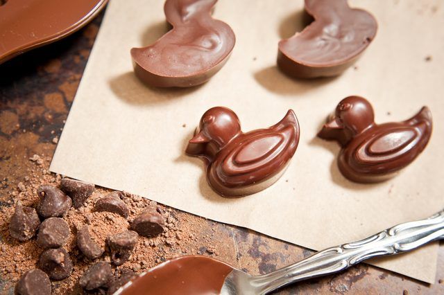 there are chocolates shaped like ducks on the counter next to a spoon and knife