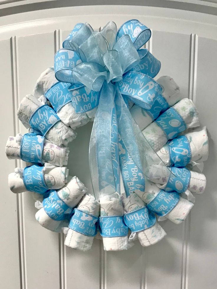 a wreath made out of toilet paper is hanging on the front door with blue ribbon