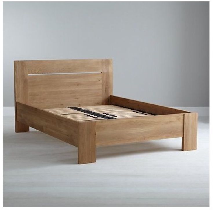 a wooden bed frame sitting on top of a white floor