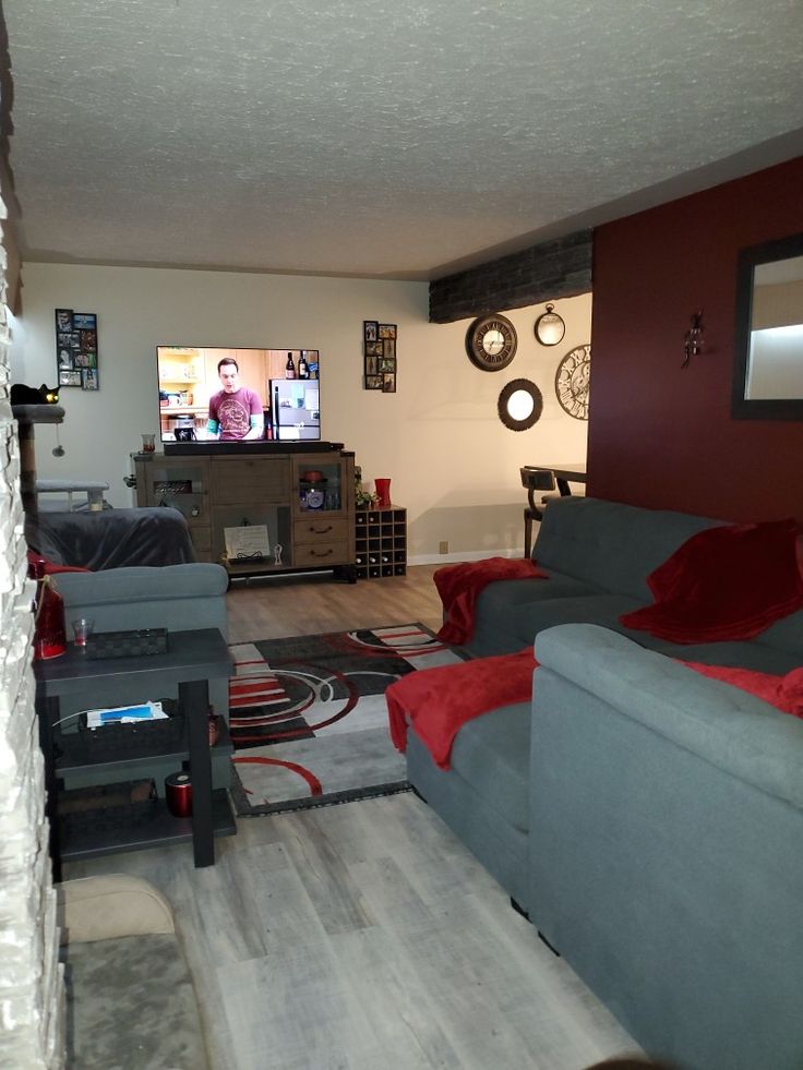 a living room filled with furniture and a flat screen tv mounted to the side of a wall