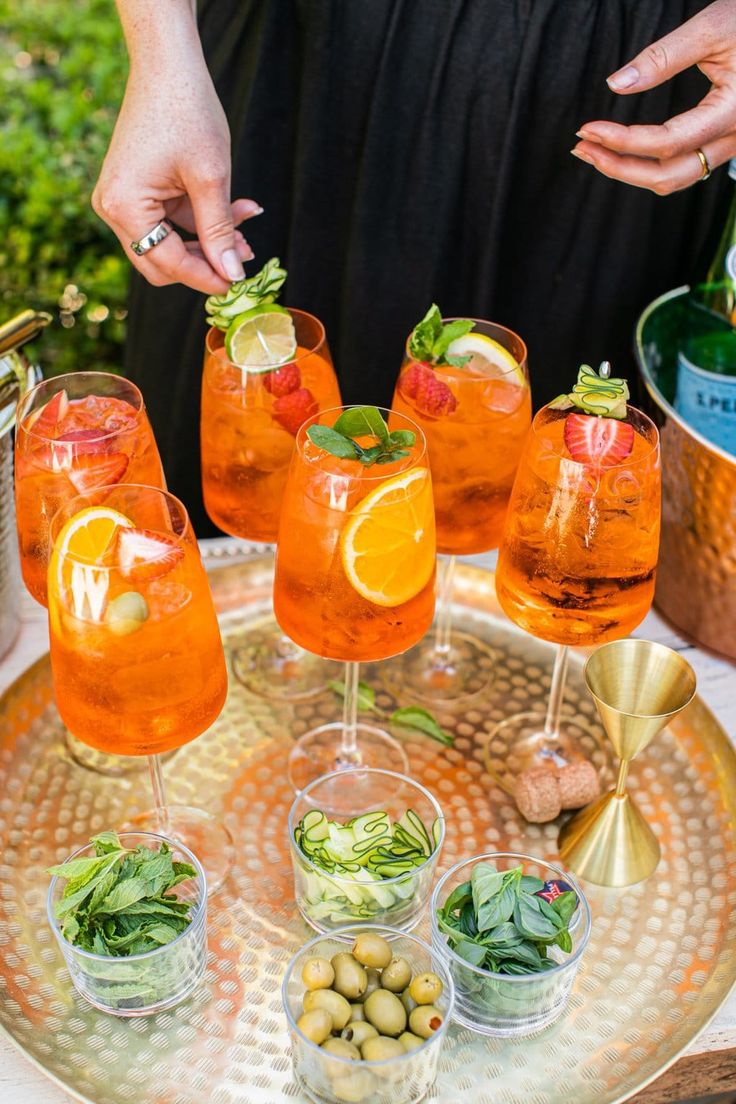 a tray topped with glasses filled with drinks and garnished with lemon wedges