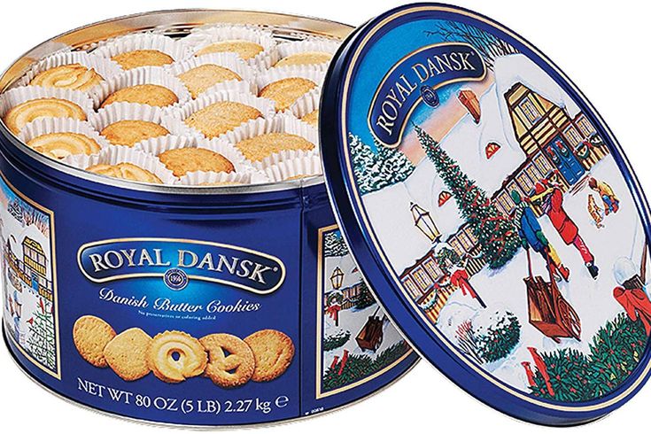 royal danish cookies in a tin on a white background with the lid open to show an image of a christmas scene