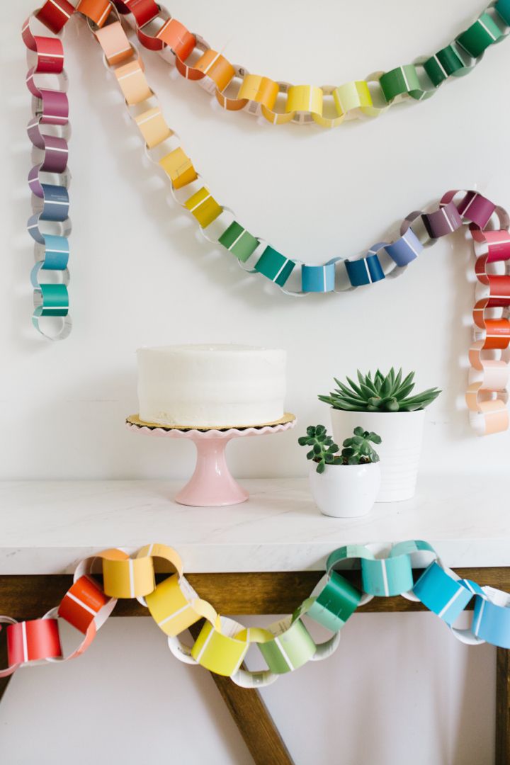 a cake sitting on top of a table next to a potted plant and rainbow ribbon