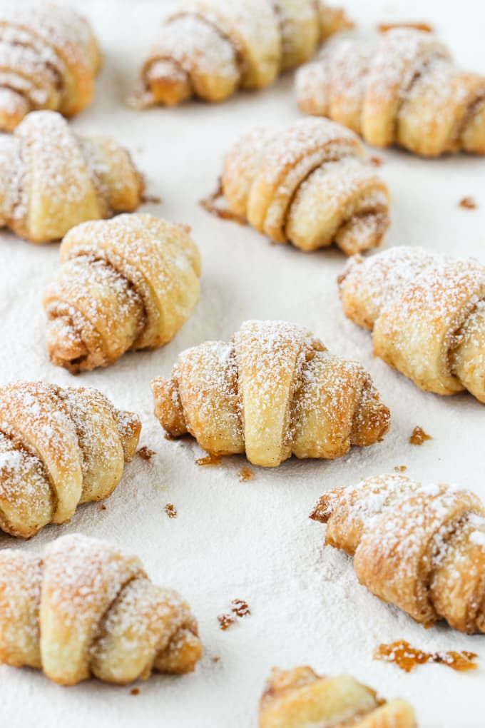 powdered sugar croissants are lined up on a baking sheet and ready to be eaten