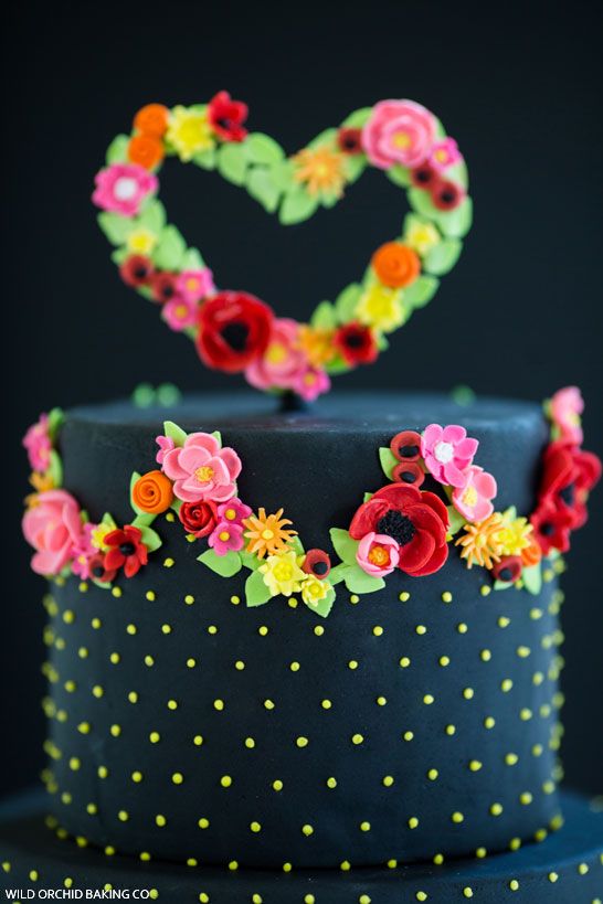 a cake decorated with flowers and hearts on top