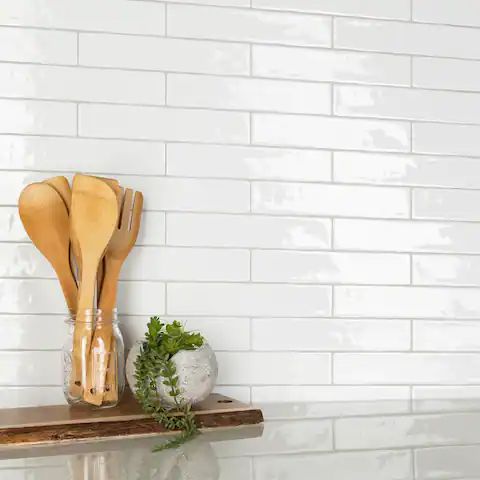 some wooden utensils are sitting on a shelf next to a white brick wall