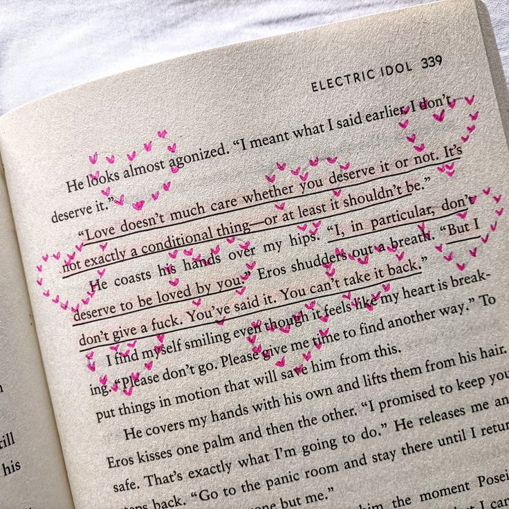 an open book with pink hearts on it