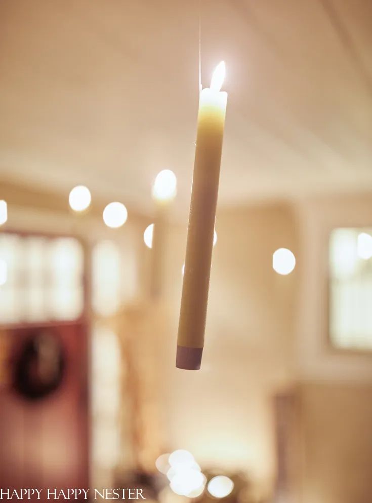 a lit candle hanging from the ceiling in a living room