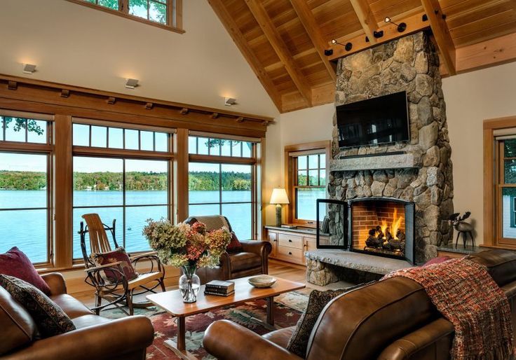 a living room filled with furniture and a fire place in front of a large window