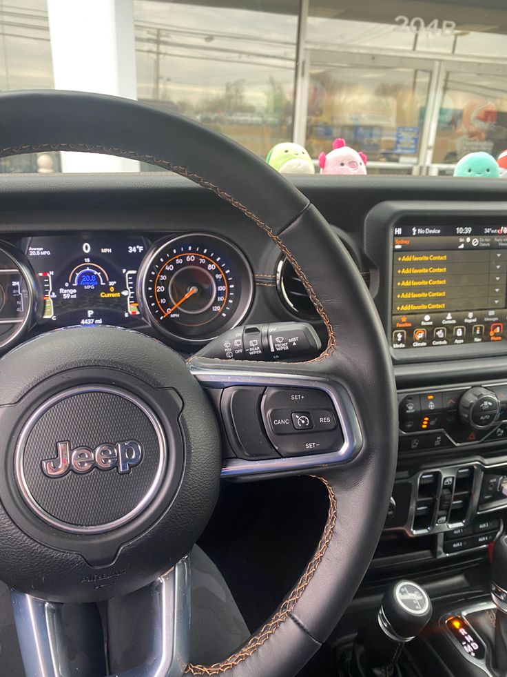 the steering wheel and dashboard of a jeep