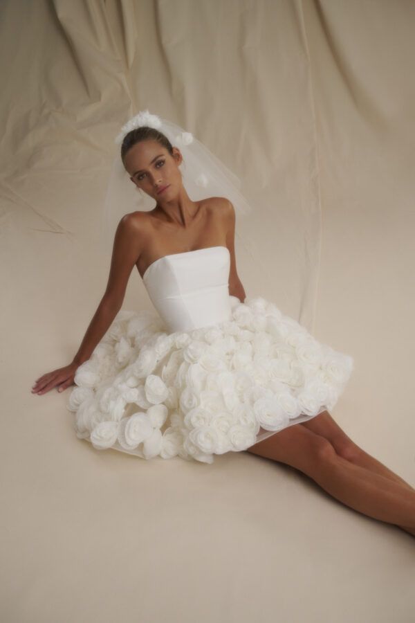 a woman in a wedding dress sitting on the floor