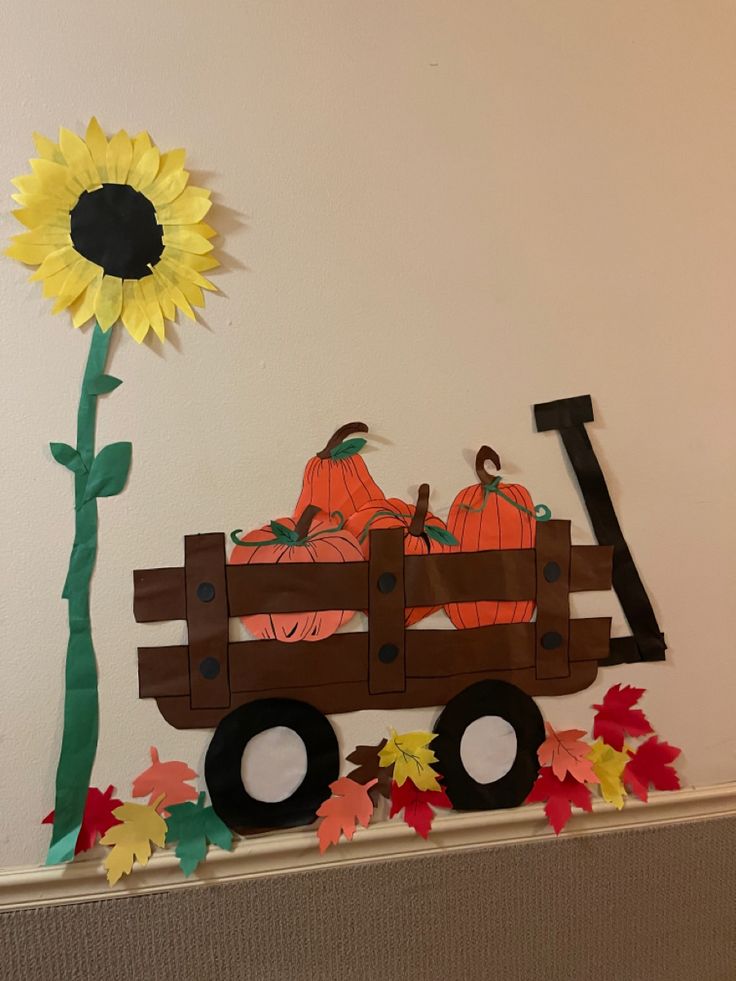 a paper sunflower sitting on top of a truck with pumpkins in the back