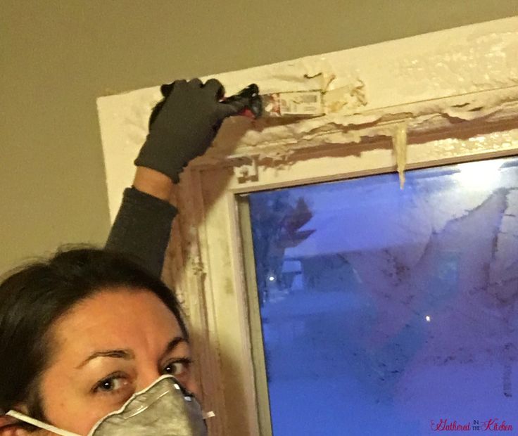 a woman wearing a mask and gloves is looking out the window