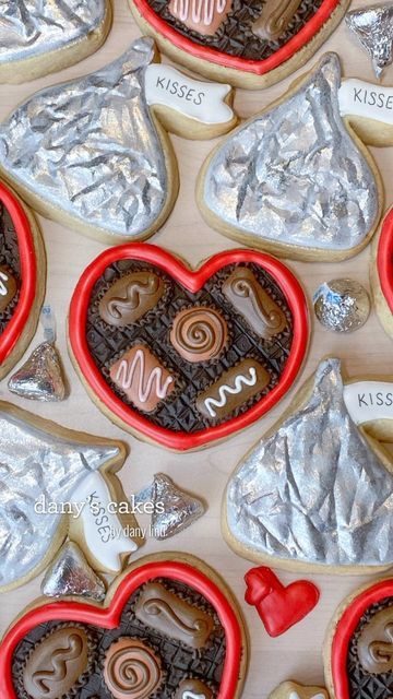 cookies in the shape of hearts with chocolates and candy on them are displayed for valentine's day