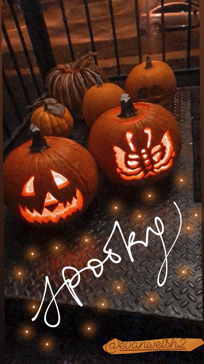 three carved pumpkins sitting on top of a metal surface with the words happy written in white